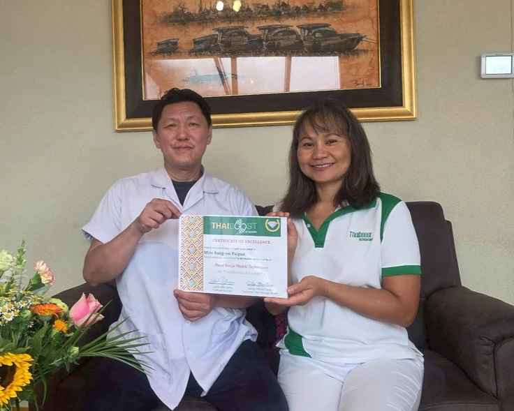 Mijn leraar en ik tonen samen mijn certificaat van ThaiBoost